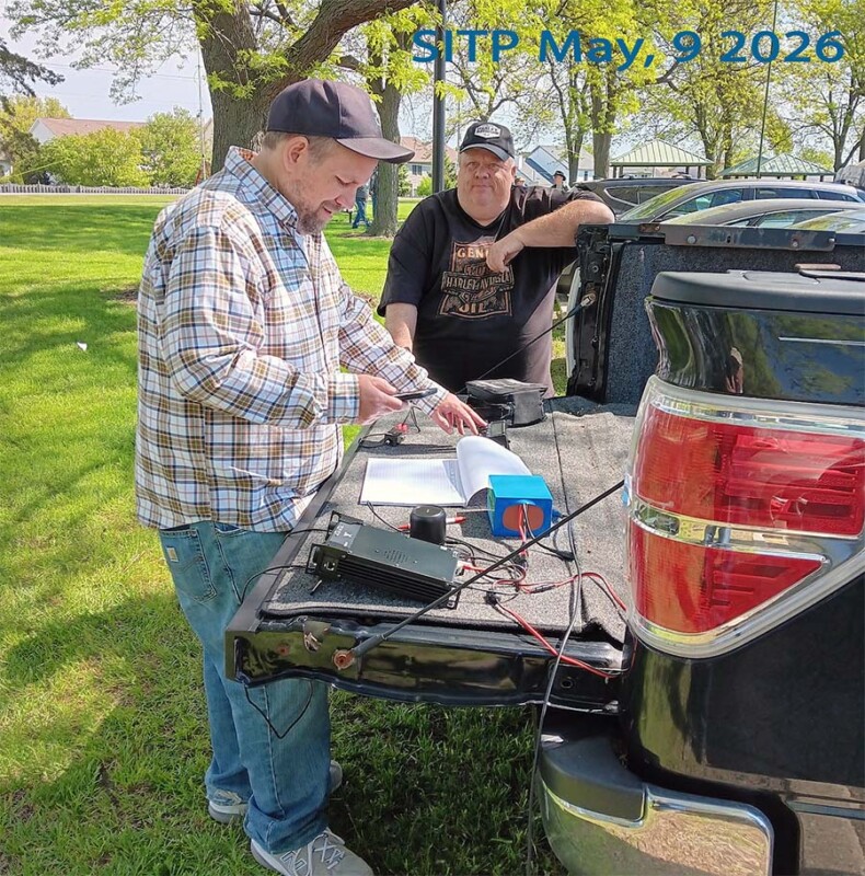 Andrew Rafferty (K9ABR) working CW with an end-fed dipole antenna up in a tree, with Jeff L. Gembala (N9QF) watching.