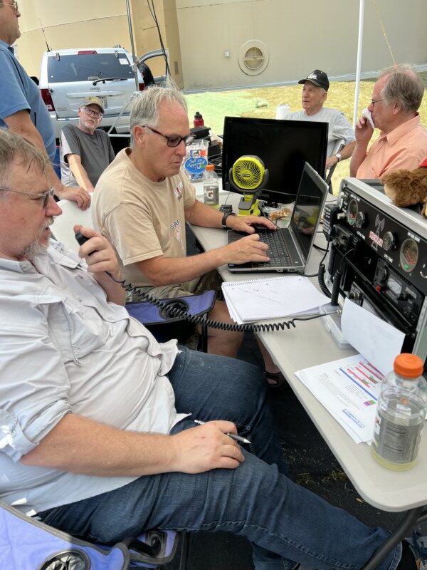 Portable amateur radio field day station with antennas in a field